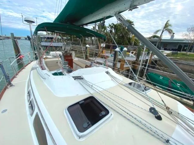 Slide: The Image of Sailboat Freedom 45, 1992 model, docked with green canopy and visible rigging. - 10