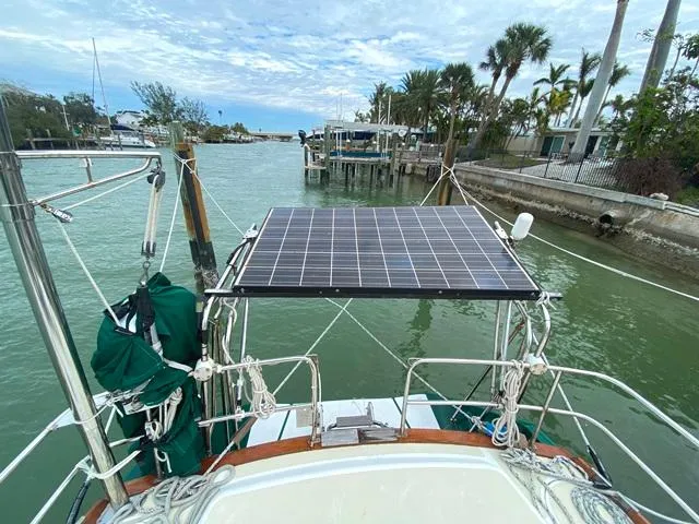 Slide: The Image of Sailboat with solar panel on deck, docked in a scenic marina, Freedom 45 model, 1992. - 14