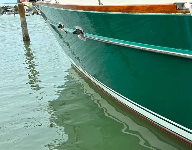 Slide: The Image of Green Freedom 45 sailboat from 1992 docked on calm water. - 2