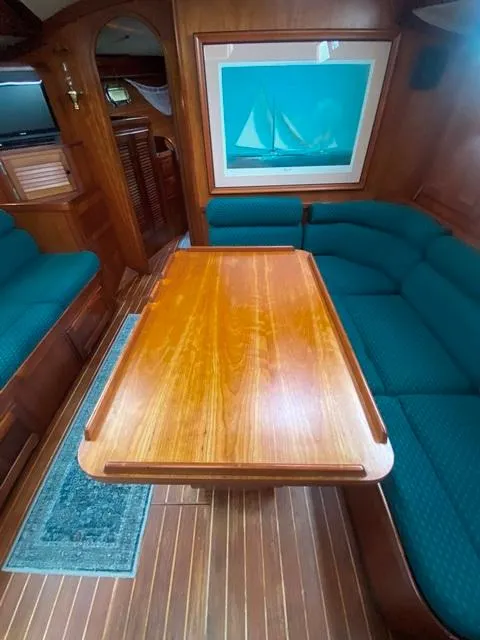 Slide: The Image of Interior of a 1992 Freedom 45 yacht with wooden table and teal seating. - 27