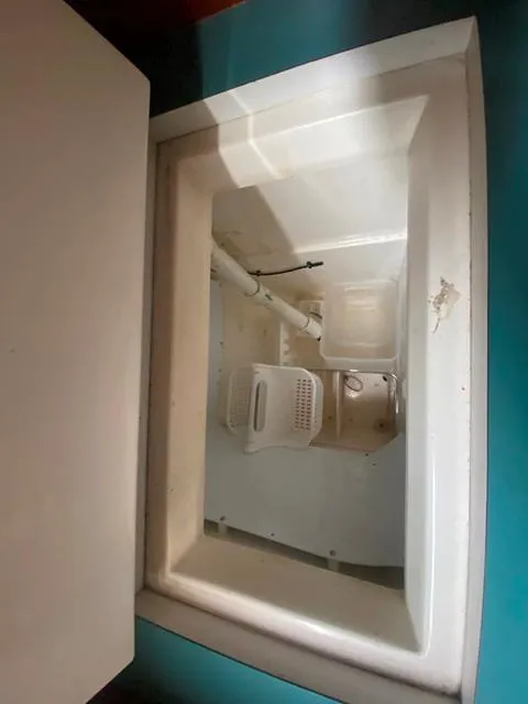 Slide: The Image of White storage compartment on Freedom 45 boat, 1992 model, with visible pipes and containers. - 32