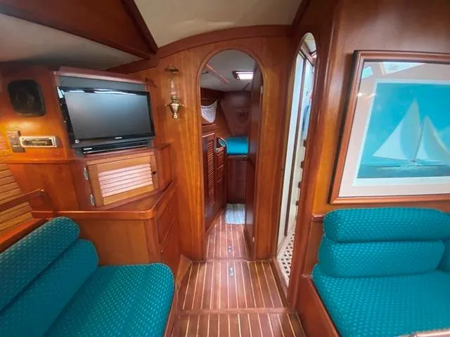 Slide: The Image of Interior of 1992 Freedom 45 yacht with wood paneling, teal seating, and a wall-mounted TV. - 33