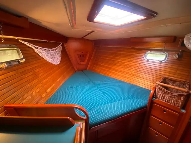 Slide: The Image of Cozy cabin interior of 1992 Freedom 45 sailboat with wooden paneling and teal bedding. - 34