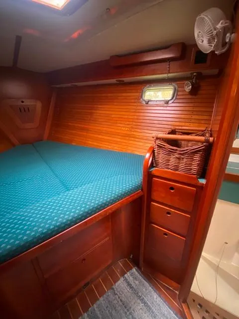 Slide: The Image of Cozy cabin interior of 1992 Freedom 45 sailboat with wooden finish and teal bedding. - 36