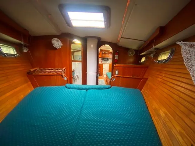 Slide: The Image of Cozy cabin interior of 1992 Freedom 45 sailboat with wooden paneling and teal bedding. - 37