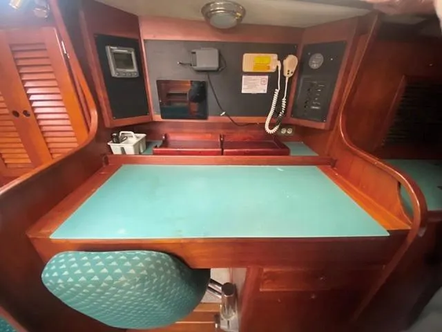 Slide: The Image of 1992 Freedom 45 yacht interior with navigation station, teal desk, and wooden cabinetry. - 42