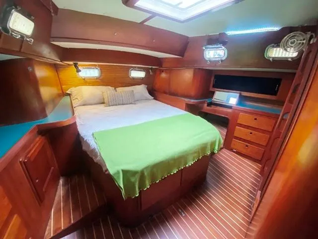 Slide: The Image of Luxurious cabin interior of 1992 Freedom 45 yacht with wooden furnishings and cozy bedding. - 43