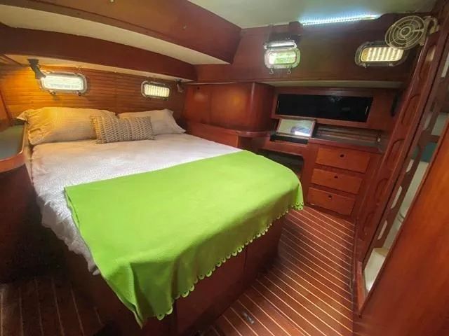Slide: The Image of Cozy cabin interior of 1992 Freedom 45 yacht with wooden finish and green bedspread. - 44