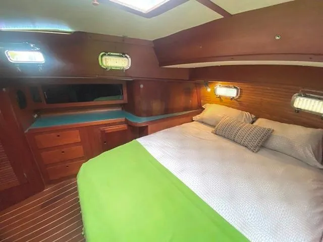 Slide: The Image of Cozy cabin interior of 1992 Freedom 45 yacht with wooden furnishings and comfortable bedding. - 46