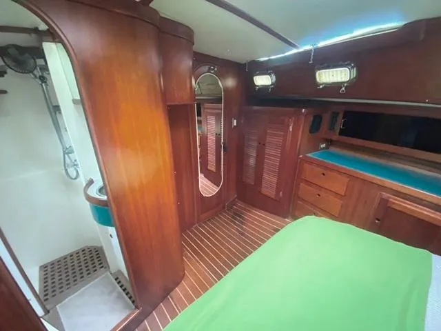 Slide: The Image of Interior of 1992 Freedom 45 sailboat with wooden cabinetry and green bedding. - 47