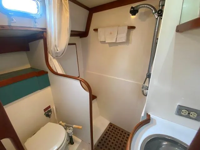 Slide: The Image of Compact bathroom in a 1992 Freedom 45 yacht, featuring a shower, toilet, and sink. - 48