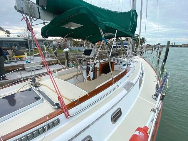 Slide: The Image of Sailboat docked at marina, Freedom 45 model, 1992, with green canopy and wooden accents. - 7