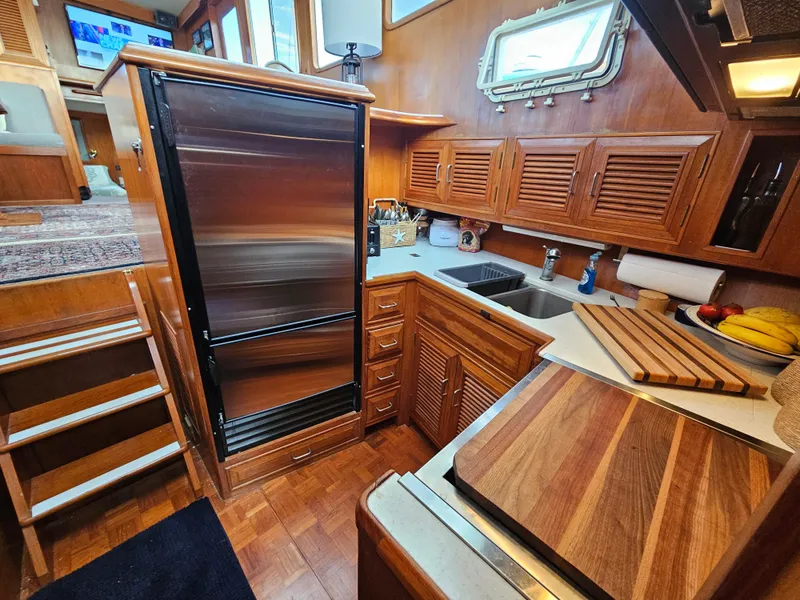 Slide: The Image of 1983 Ocean Alexander 43 yacht kitchen with wood cabinetry and stainless steel appliances. - 26