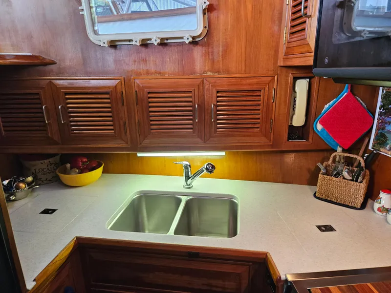 Slide: The Image of 1983 Ocean Alexander 43 yacht kitchen with wooden cabinets and double sink. - 28