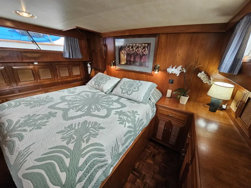 Slide: The Image of Luxurious 1983 Ocean Alexander 43 yacht bedroom with elegant wood paneling and floral bedding. - 34