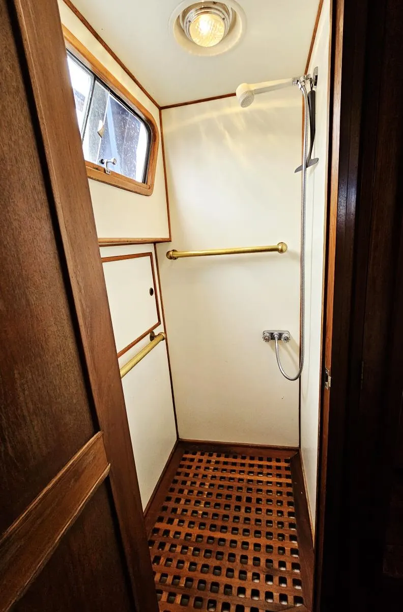 Slide: The Image of 1983 Ocean Alexander 43 yacht shower with wooden floor and brass fixtures. - 36
