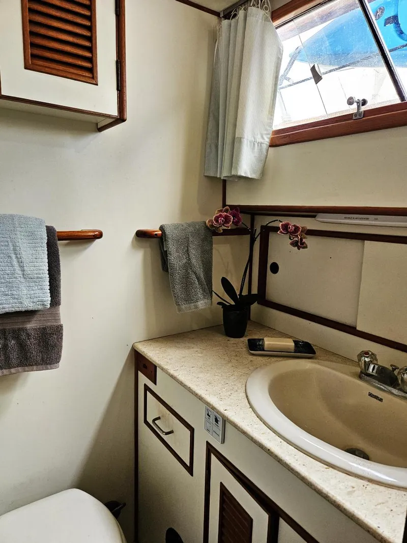 Slide: The Image of 1983 Ocean Alexander 43 yacht bathroom with sink, towels, and window. - 37