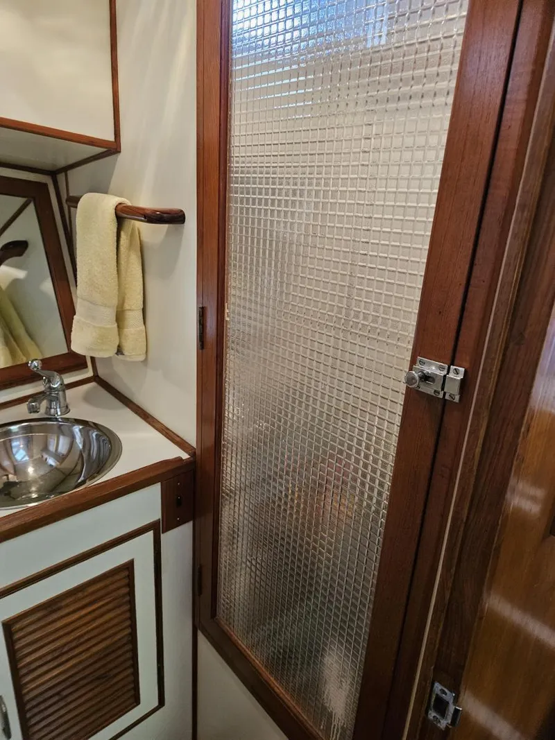 Slide: The Image of 1983 Ocean Alexander 43 bathroom with sink, towel, and textured glass door. - 40
