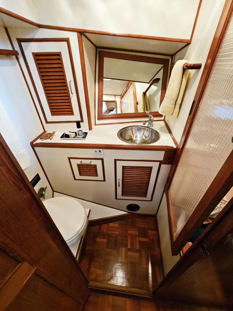 Slide: The Image of 1983 Ocean Alexander 43 yacht bathroom with wood accents and compact design. - 41