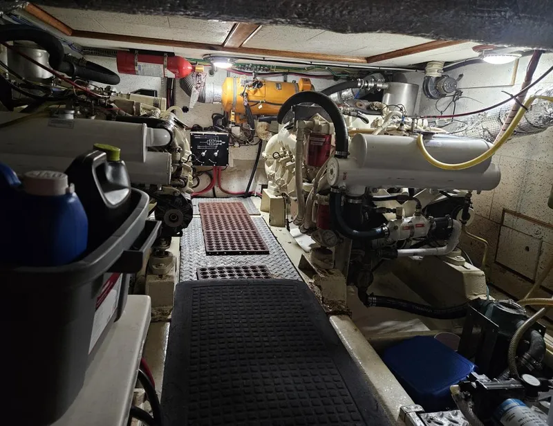 Slide: The Image of Engine room of 1983 Ocean Alexander 43 yacht, featuring dual engines and maintenance equipment. - 42