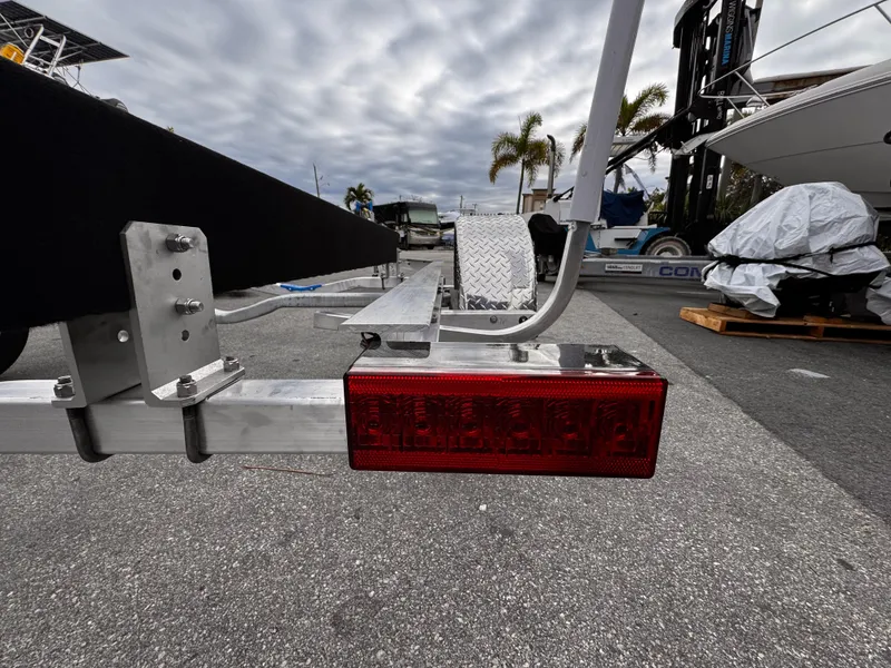 Slide: The Image of 2025 Single Axle Trailer with red taillight, parked in a marina setting. - 3