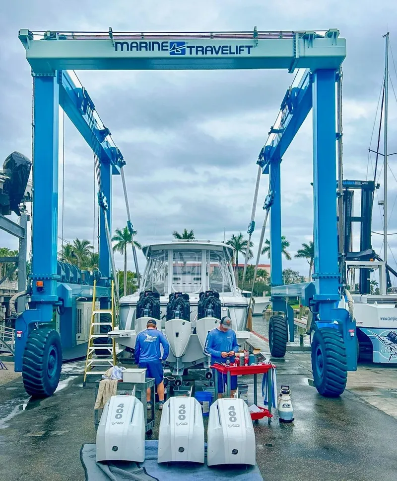 Slide: The Image of Boat maintenance under Marine Travelift with 2025 Single Axle Trailer in marina setting. - 9