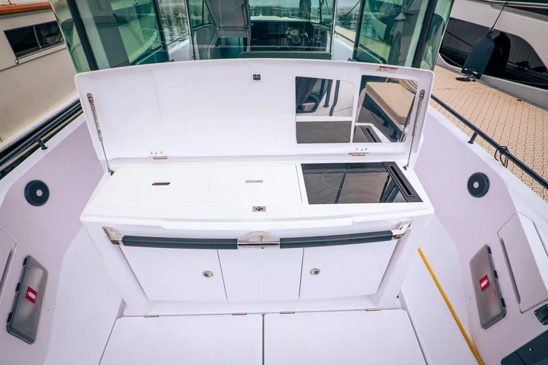 Slide: The Image of 2023 Axopar Michael Vrbas boat interior with sleek white cabinetry and modern design. - 13
