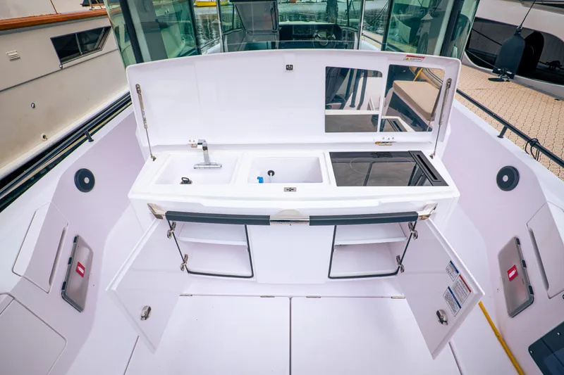 Slide: The Image of Modern Axopar Michael Vrbas 2023 boat kitchen with sink and storage compartments. - 14