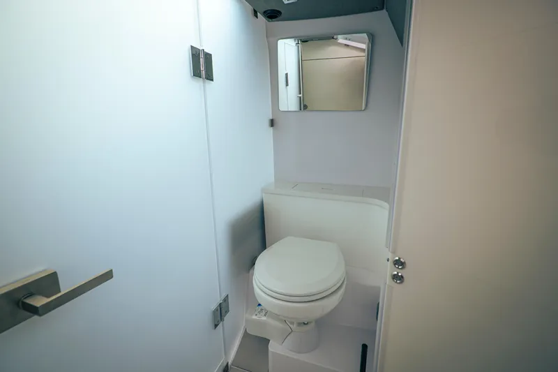 Slide: The Image of Compact bathroom in 2023 Axopar Michael Vrbas boat, featuring a toilet and mirror. - 21