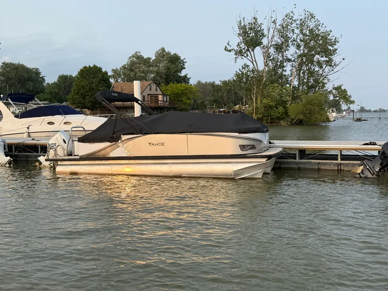 The Image of 2025 Tahoe Pontoon LTZ Quad Lounger docked on a serene lake. - 0