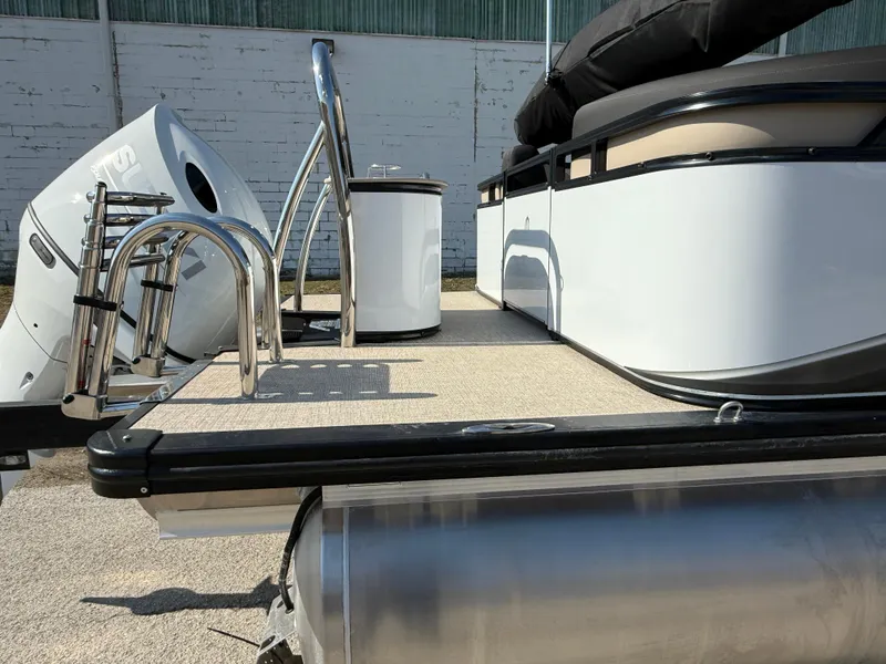 Slide: The Image of 2025 Tahoe Pontoon LTZ Quad Lounger, rear deck view with motor and ladder. - 19