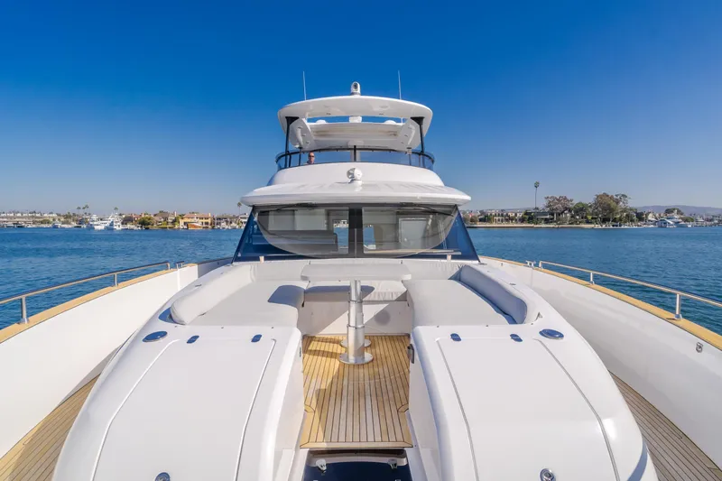 Slide: The Image of 2023 Azimut Magellano 66 yacht on calm water, showcasing sleek design and spacious deck. - 10