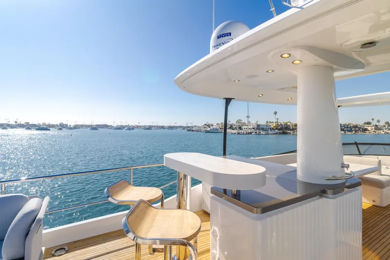 Slide: The Image of Azimut Magellano 66 yacht deck with bar stools, overlooking serene ocean view, 2023 model. - 24