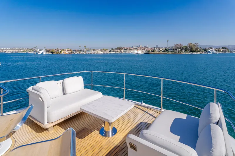 Slide: The Image of Azimut Magellano 66 yacht deck with luxurious seating, overlooking serene blue waters, 2023 model. - 26