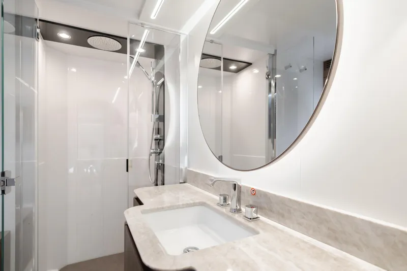 Slide: The Image of Luxurious bathroom in 2023 Azimut Magellano 66 yacht with modern fixtures and round mirror. - 46
