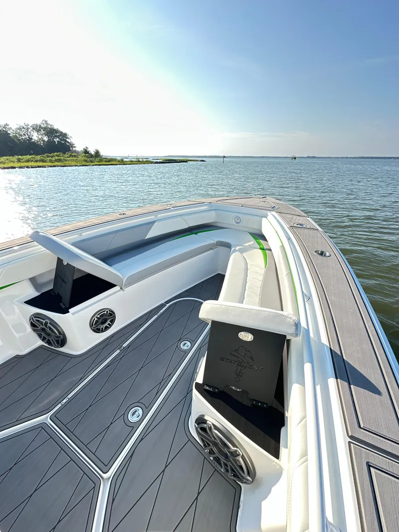 Slide: The Image of 2023 Statement 350 Open boat on calm water, featuring sleek deck design and seating. - 16