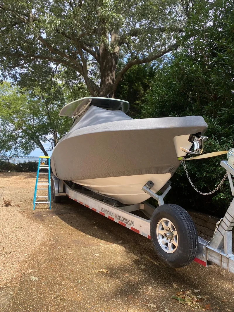 Slide: The Image of 2023 Statement 350 Open boat on trailer under trees. - 31