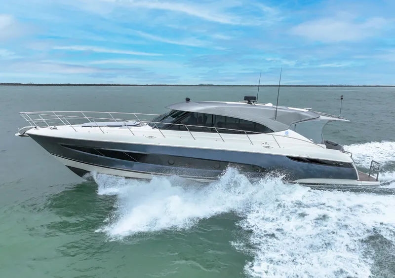 Slide: The Image of Riviera 5400 Sport Yacht 2021 cruising on open water under a clear blue sky. - 18