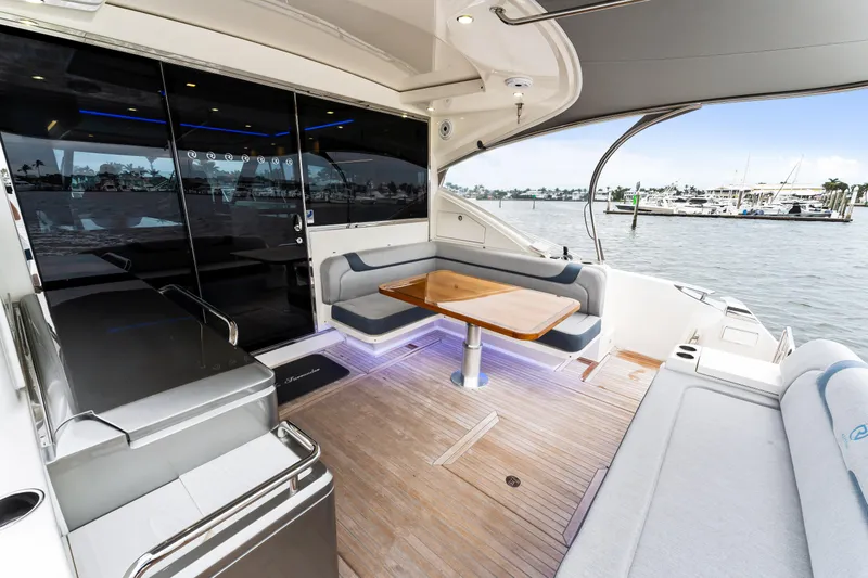 Slide: The Image of 2021 Riviera 5400 Sport Yacht interior with elegant seating and waterfront view. - 20
