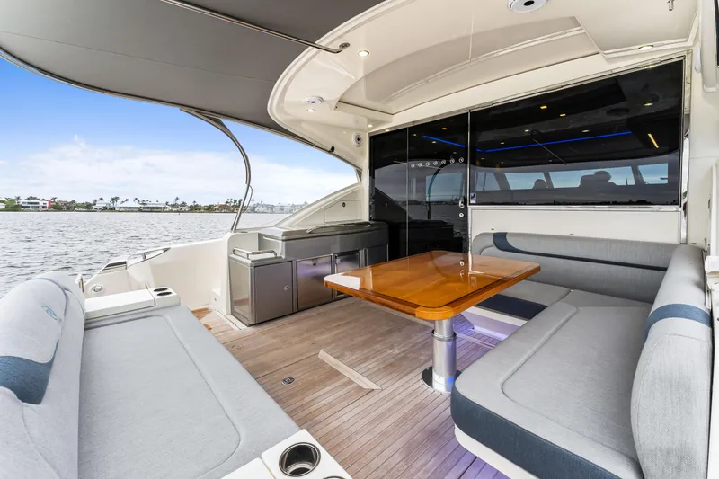 Slide: The Image of Luxurious 2021 Riviera 5400 Sport Yacht interior with elegant seating and wooden table. - 23