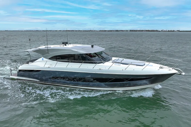 Slide: The Image of 2021 Riviera 5400 Sport Yacht cruising on open water under a clear blue sky. - 4