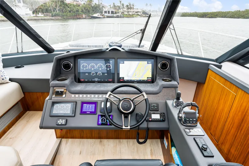 Slide: The Image of 2021 Riviera 5400 Sport Yacht helm with advanced navigation displays and controls. - 44