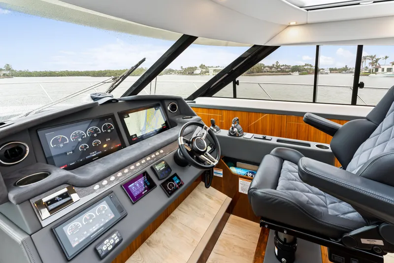 Slide: The Image of Interior helm of 2021 Riviera 5400 Sport Yacht with modern controls and leather seating. - 46