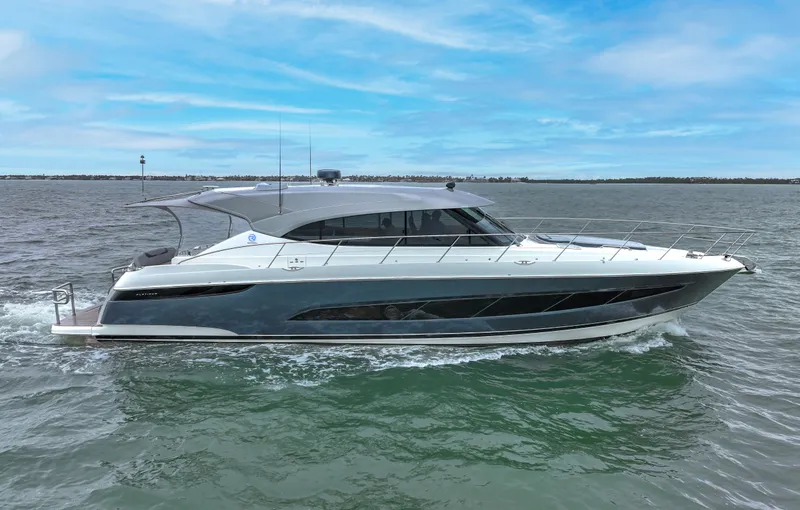 Slide: The Image of 2021 Riviera 5400 Sport Yacht cruising on open water under a clear blue sky. - 5