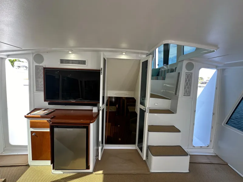Slide: The Image of Interior of 1999 Viking 60 Cockpit Sports Yacht with stairs, TV, and mini fridge. - 11