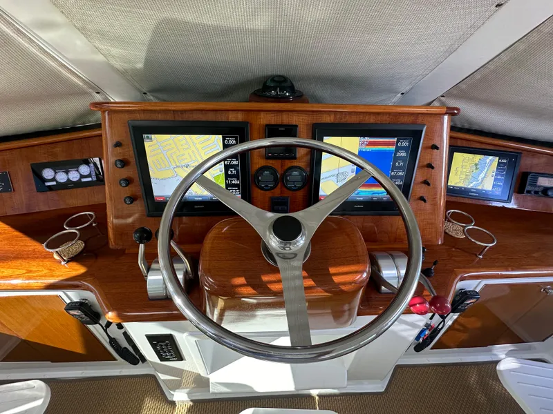 Slide: The Image of Cockpit of 1999 Viking 60 Sports Yacht with navigation screens and wooden steering wheel. - 16