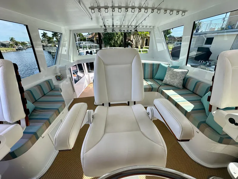 Slide: The Image of 1999 Viking 60 Cockpit Sports Yacht interior with white seating and striped cushions. - 18
