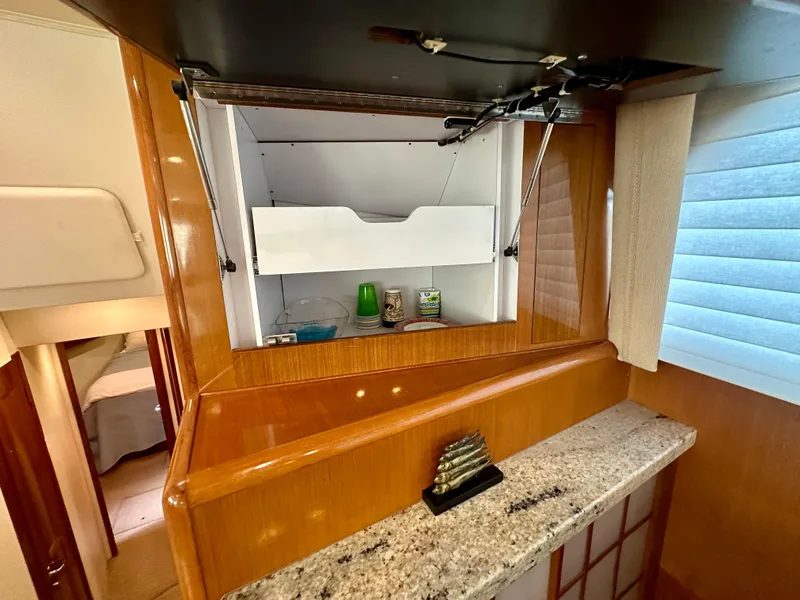 Slide: The Image of Interior of 1999 Viking 60 Cockpit Sports Yacht with open cabinet and granite countertop. - 23