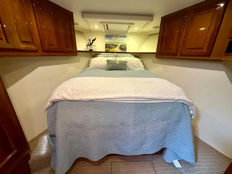 Slide: The Image of Luxurious bedroom in 1999 Viking 60 Cockpit Sports Yacht with cozy bedding and wooden cabinets. - 30