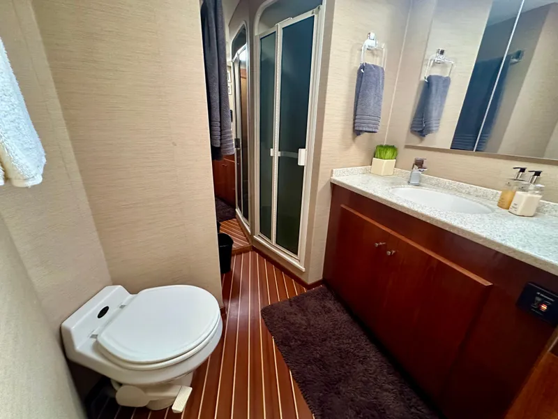 Slide: The Image of Bathroom interior of 1999 Viking 60 Cockpit Sports Yacht with shower, toilet, and vanity. - 33